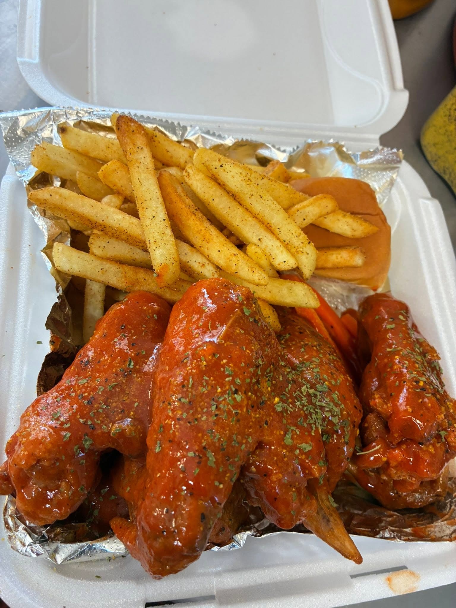 Hot wings piled over seasoned fries