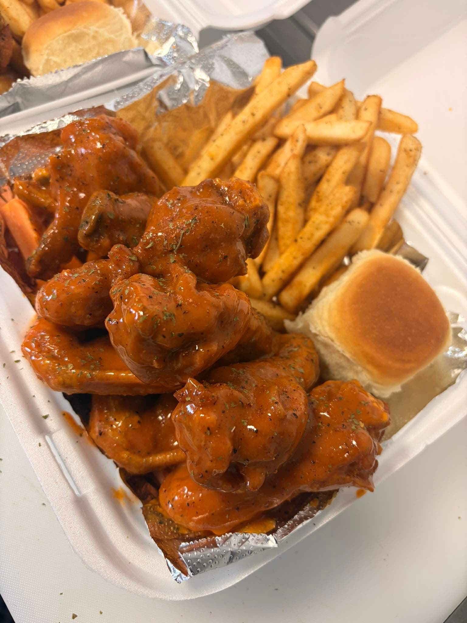 A loaded box of wings and fries